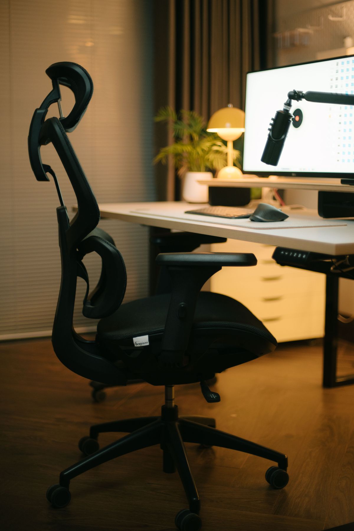 Silla de escritorio con reposacabezas junto a una mesa de trabajo