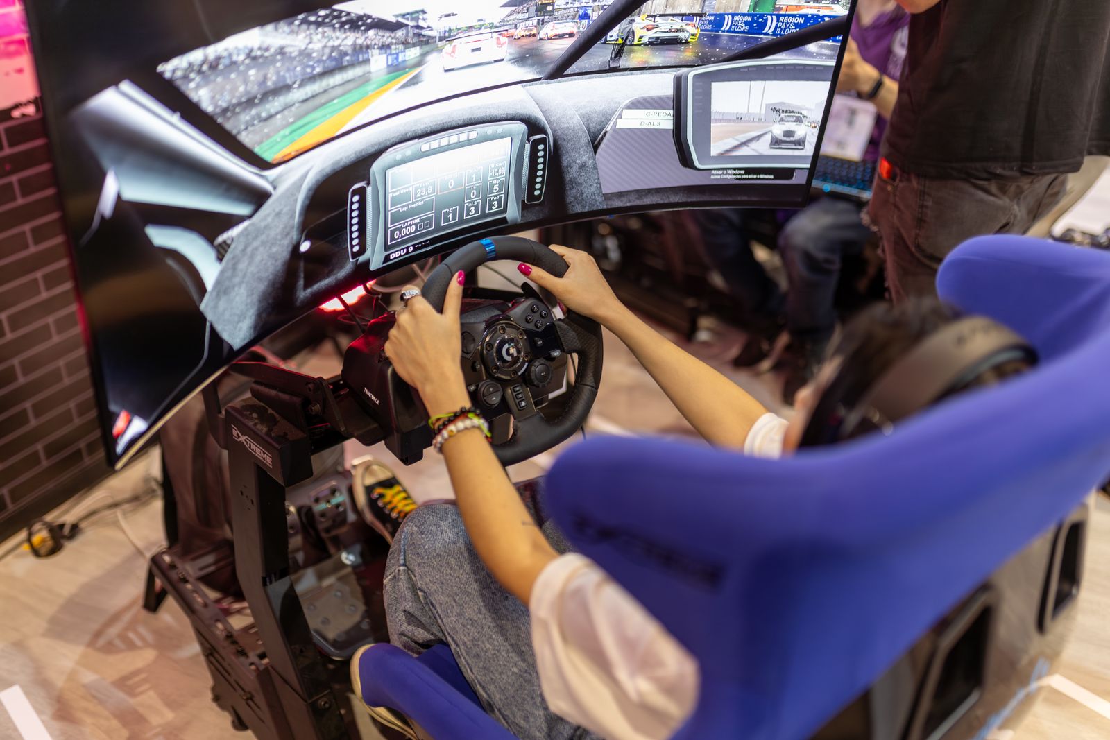 Cockpit de simracing con volante, asiento envolvente y pantalla curva